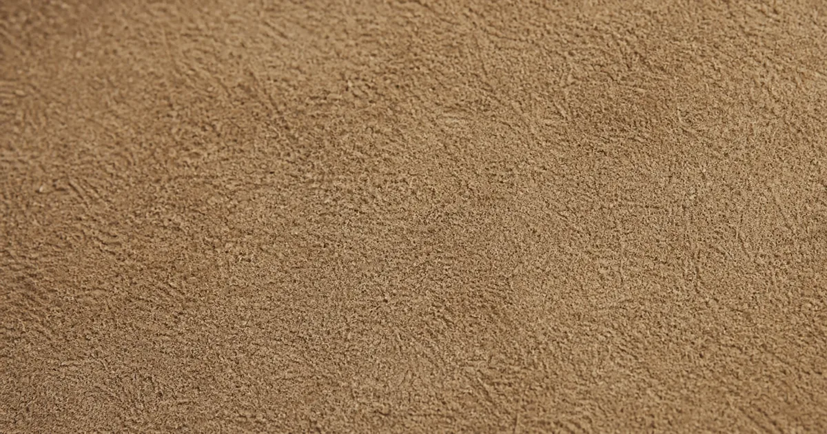 A close-up of a small piece of nubuck leather, showing the fine velvety nap on the outer-grain side, soft to touch but with the underlying grain structure still strong (AI generated illustration)
